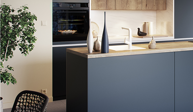 Cuisine moderne avec îlot central bleu, évier blanc, objets décoratifs, four encastré noir et plante verte à gauche.