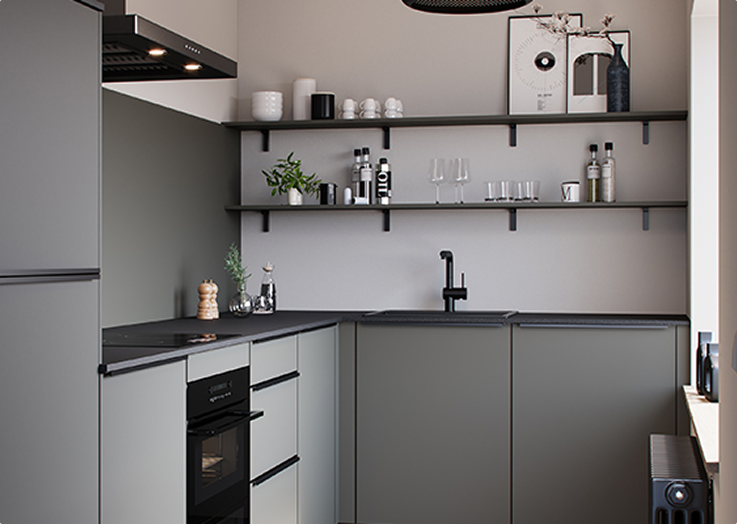 Cuisine moderne aux armoires grises avec étagères noires, décorée de plantes, verres, épices et objets décoratifs. Évier noir et four encastré visibles.