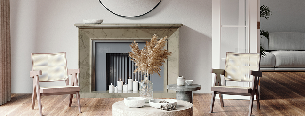 Deux fauteuils en bois entourent une table basse avec un vase de pampas, devant une cheminée décorative en marbre.